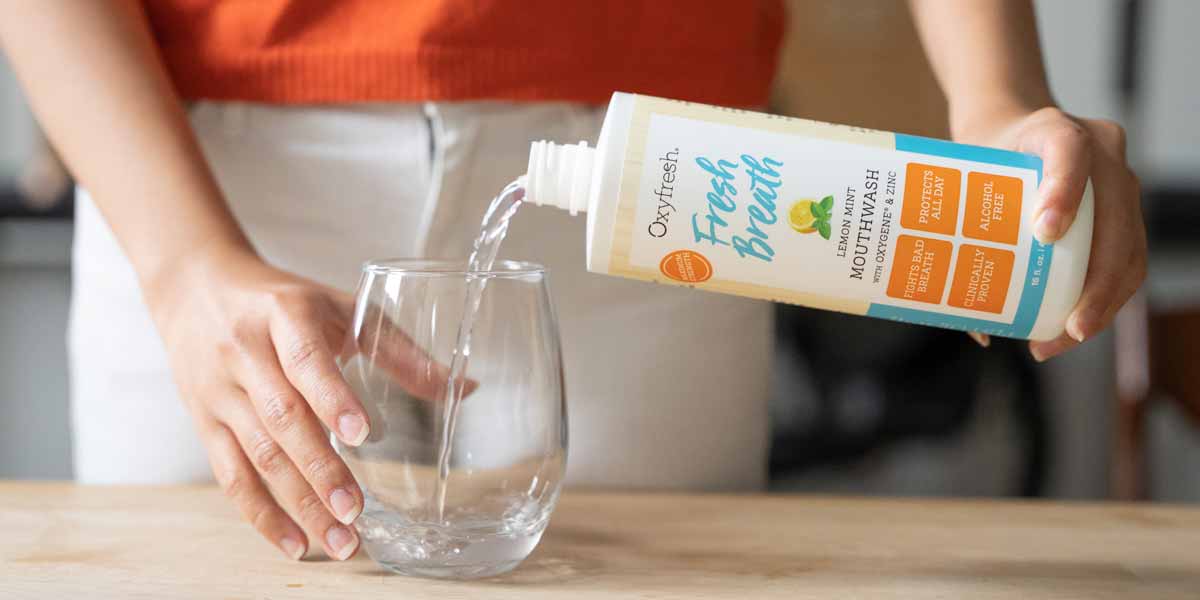 Closeup-of-alcohol-free-lemon-mint-mouthwash-being-poured-into-a-mouthwash-glass