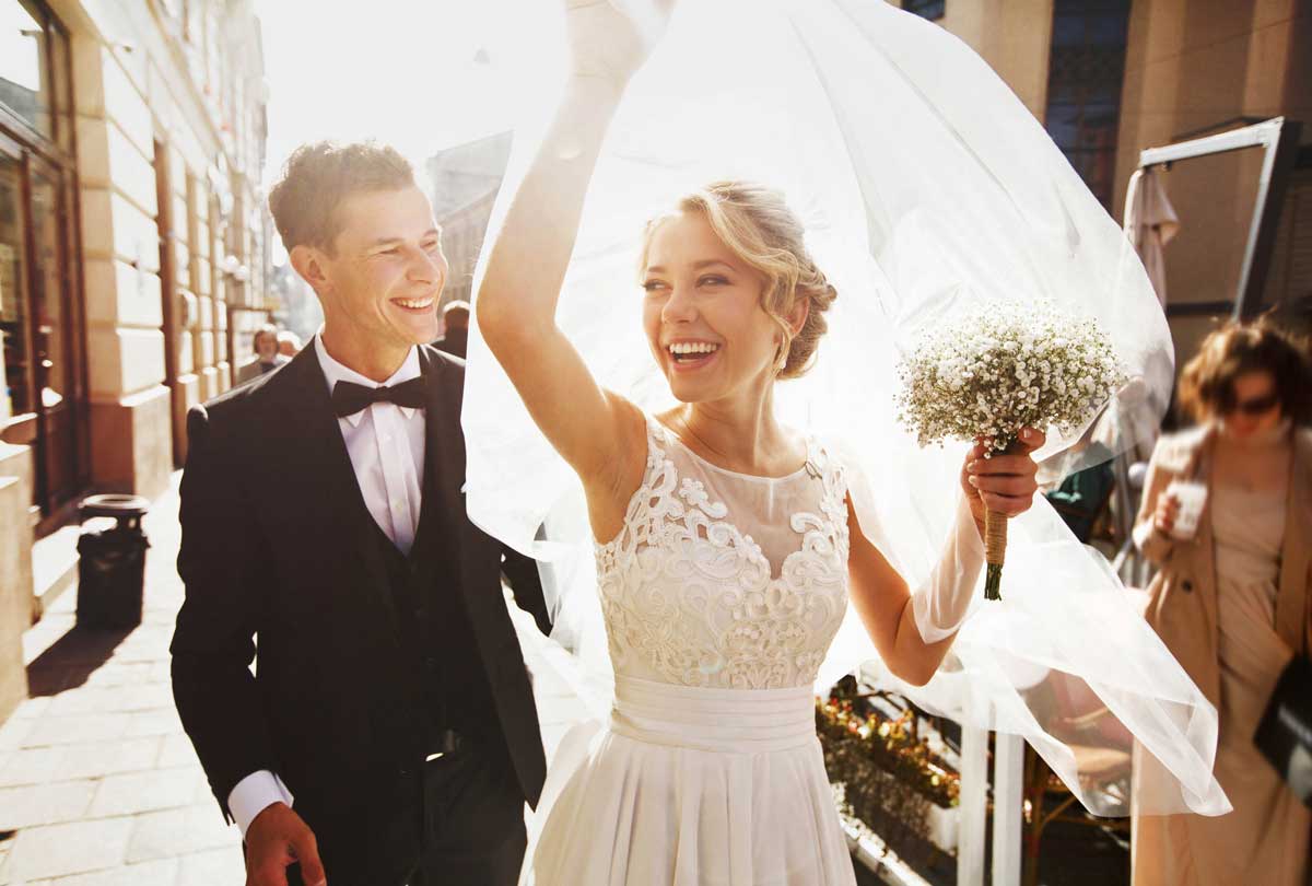 oxyfresh - 3 diy teeth whitening tips for your wedding day image of bride and groom happily walking outside after their ceremony