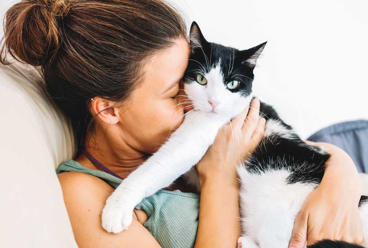 featured-image-for-oxyfresh-pet-blog-post-titled-Top-Cat-Dental-Trend-of-2022-Cat-Breath-Freshener-woman-and-cat-cuddling-on-couch