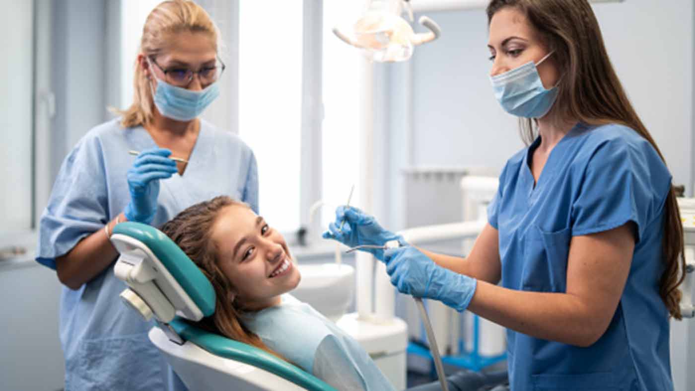 girl in dentist chair smiling at the camera