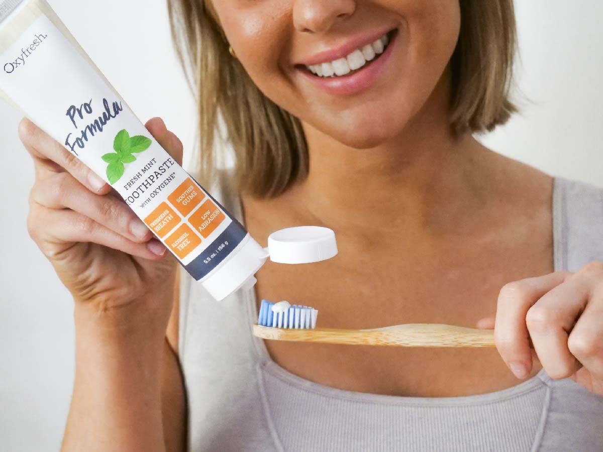 Oxyfresh-pro-formula-toothpaste_copy_woman-putting-oxyfresh-pro-formula-professional-toothpaste-onto-toothbrush