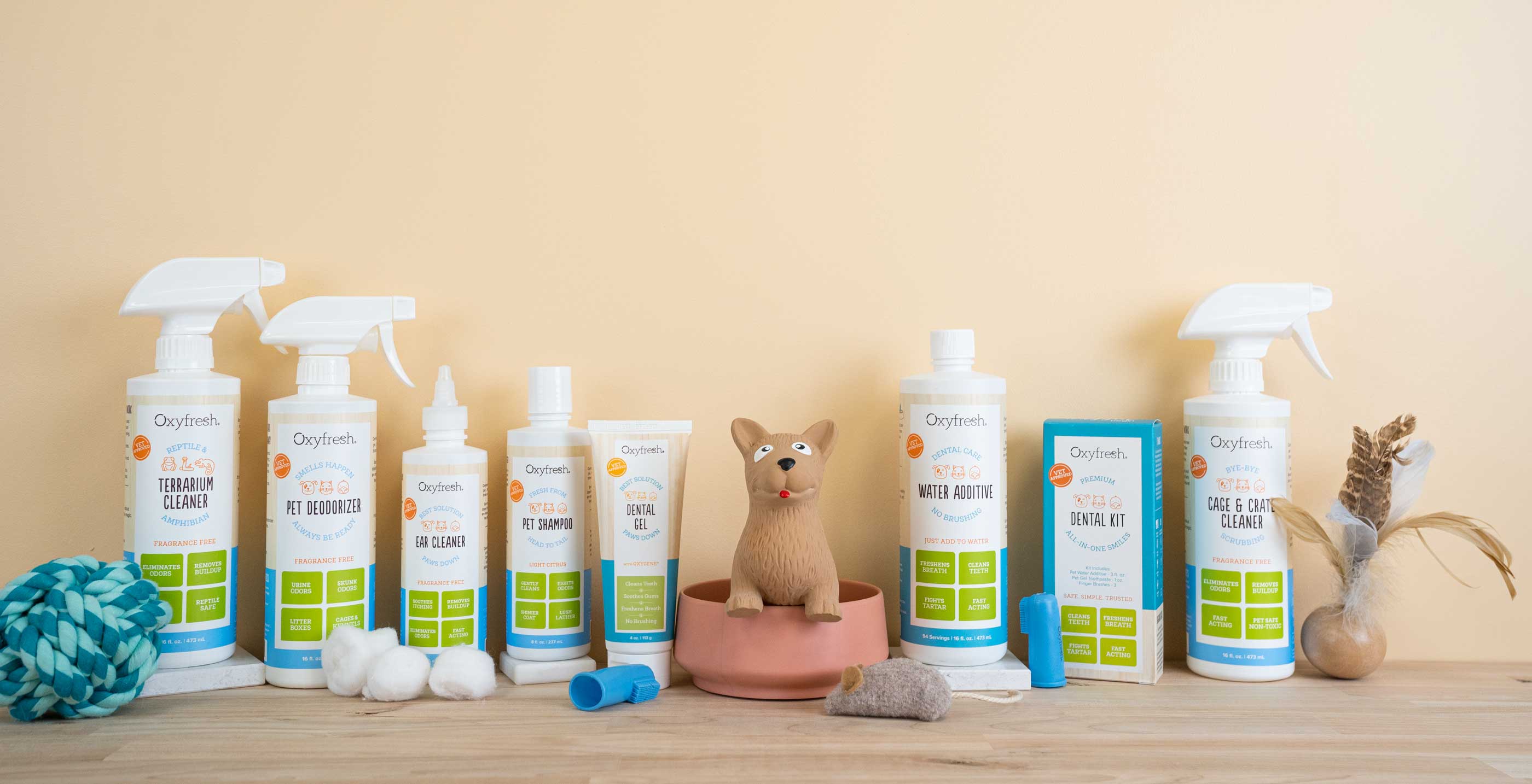 oxyfresh pet line bottles of cleaner, deodorizer, and pet dental care items dispersed with pet toys